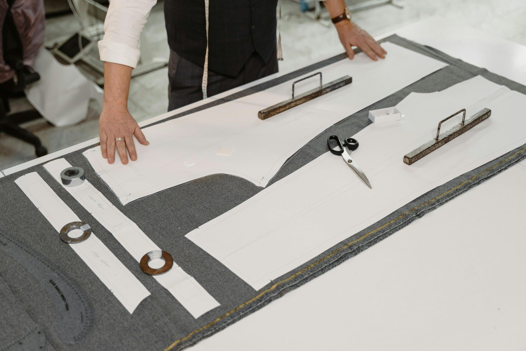 Tailor working with fabric patterns, representing bespoke relocation analysis