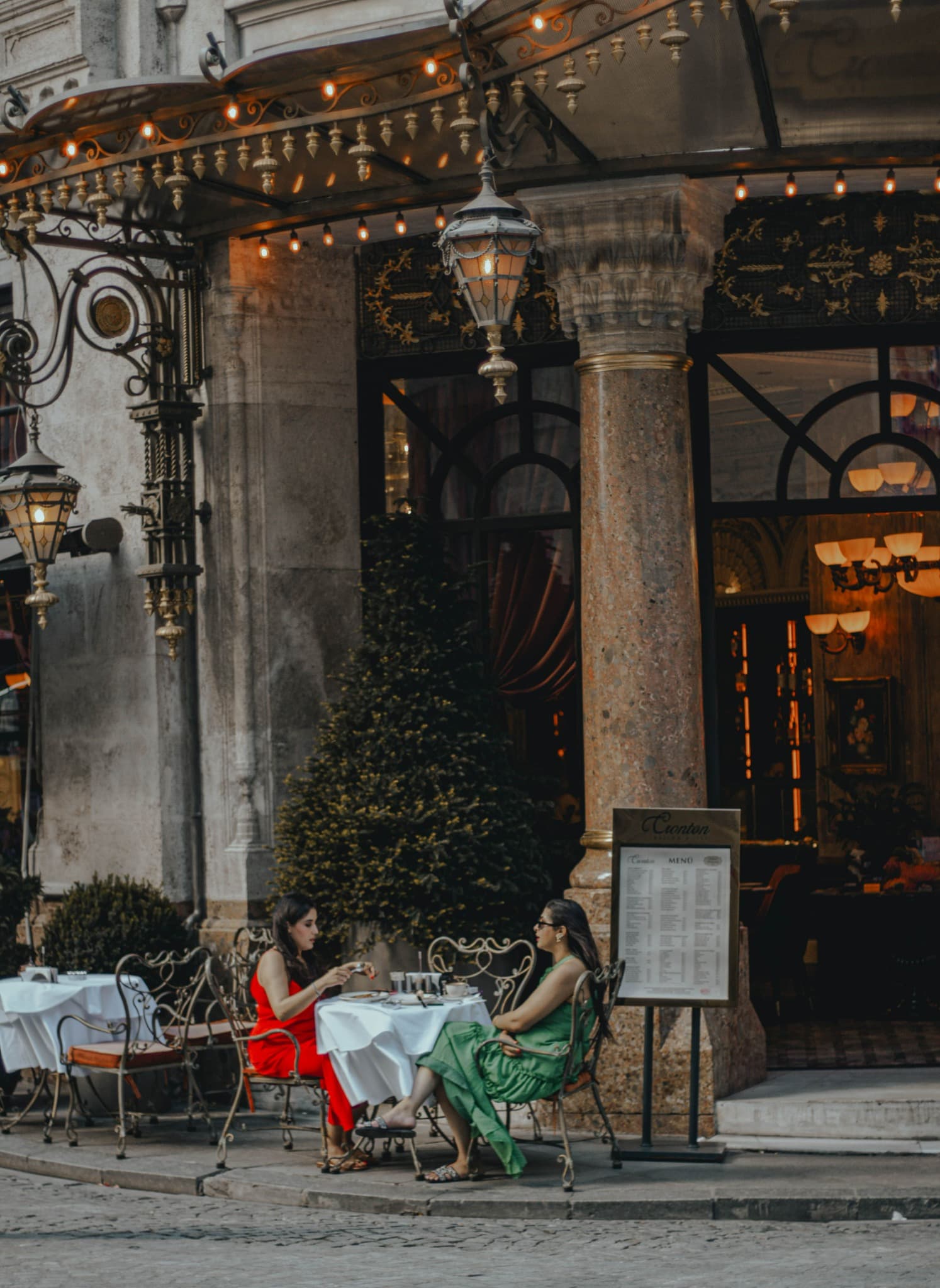 Two people enjoying an elegant outdoor café setting abroad, representing Location Advantage