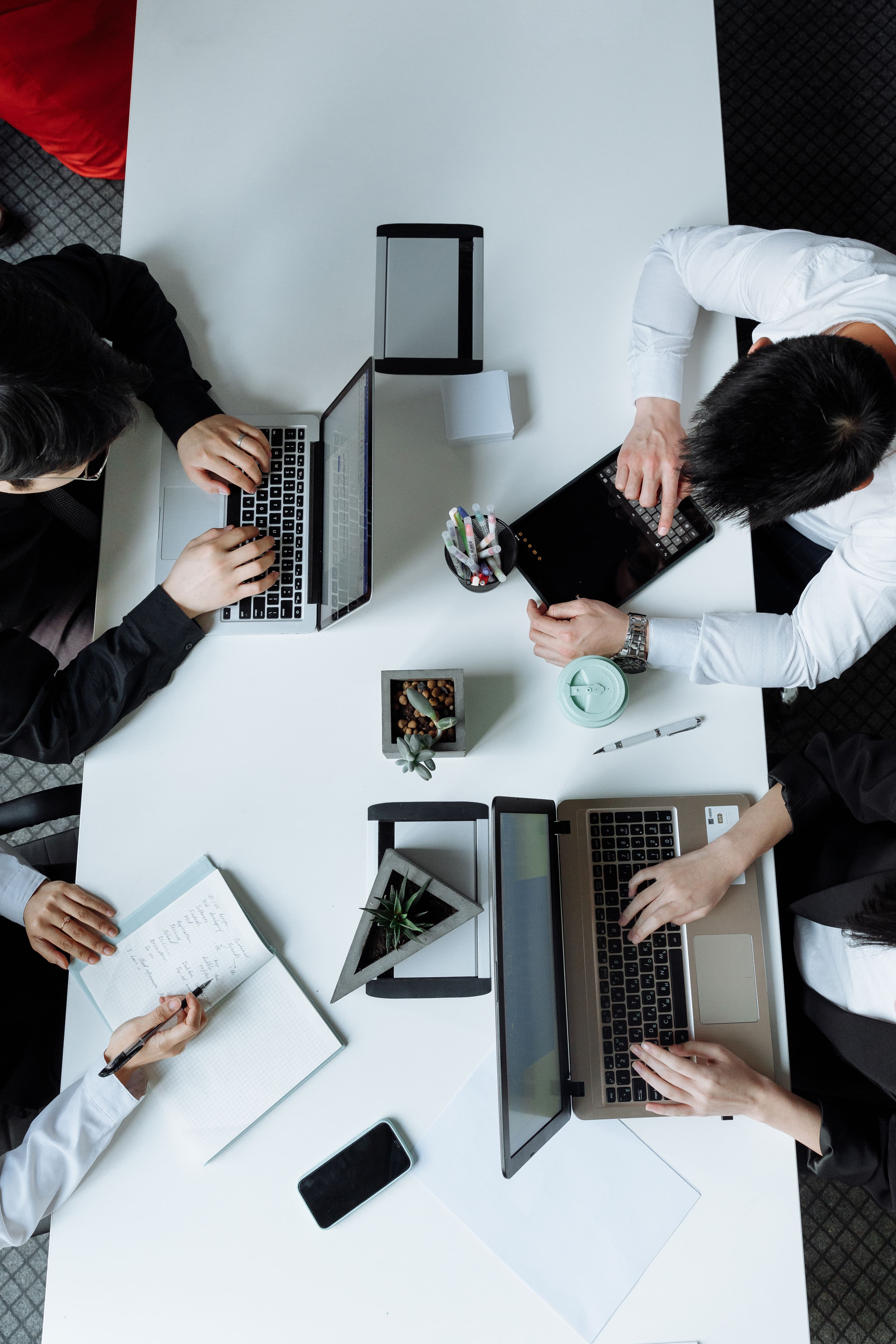 A research team reviewing relocation data, charts, and planning materials around a conference table